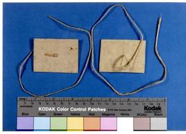 [Pormenor de pedaços de cartão e respetivos atilhos]