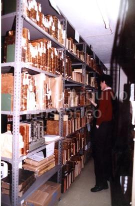 [Retrato de corpo inteiro de Francisco d'Orey Manoel junto a um corpo de estantes]