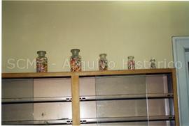 [Plano de frascos de vidro contendo cápsulas, na antiga Farmácia Central]